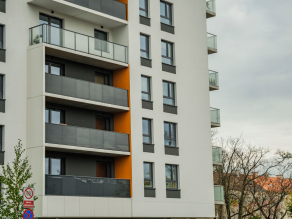 Contemporary apartment building facade with balconies on a cloudy day.