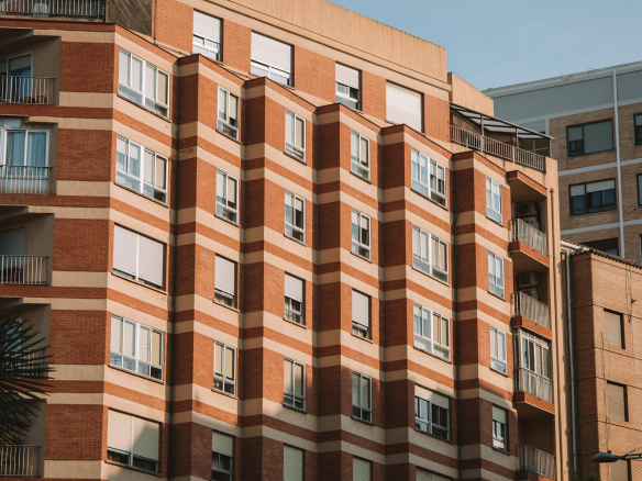 Brick apartment building in Valencia, Spain, illuminated by sunlight.