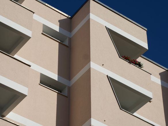 View of a modern apartment facade in Berlin, Germany with clear blue sky.