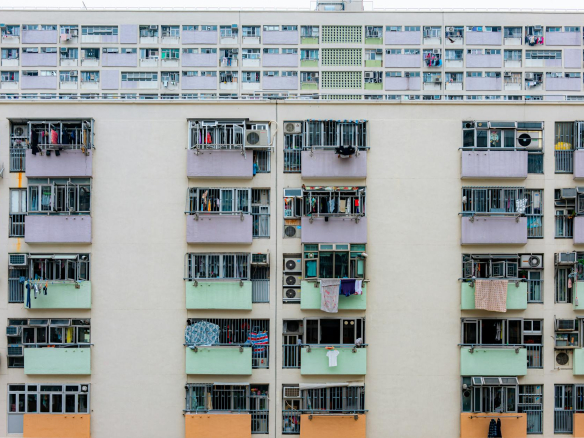Multicolored urban apartment building with balconies and windows, showcasing city living.