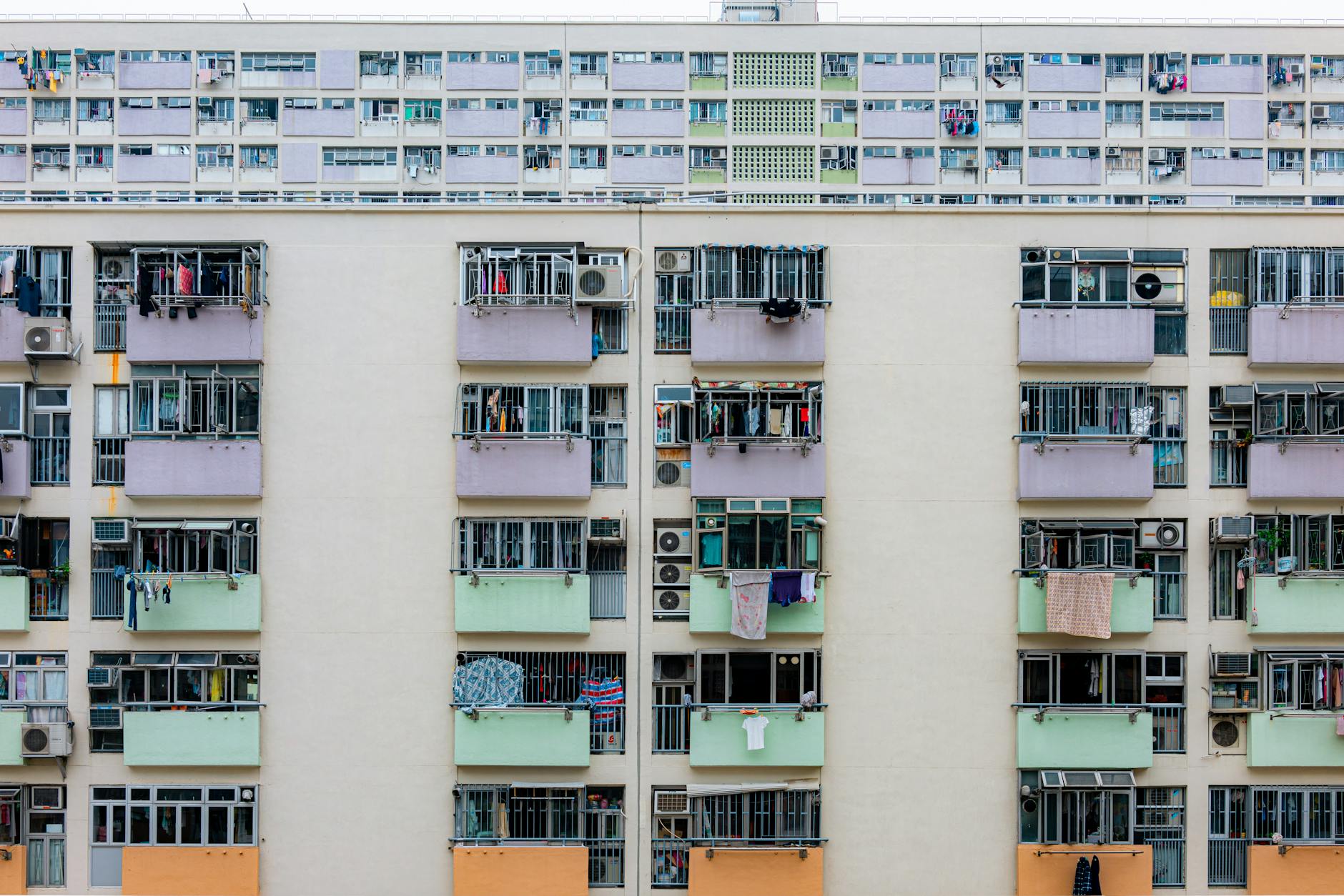 Multicolored urban apartment building with balconies and windows, showcasing city living.