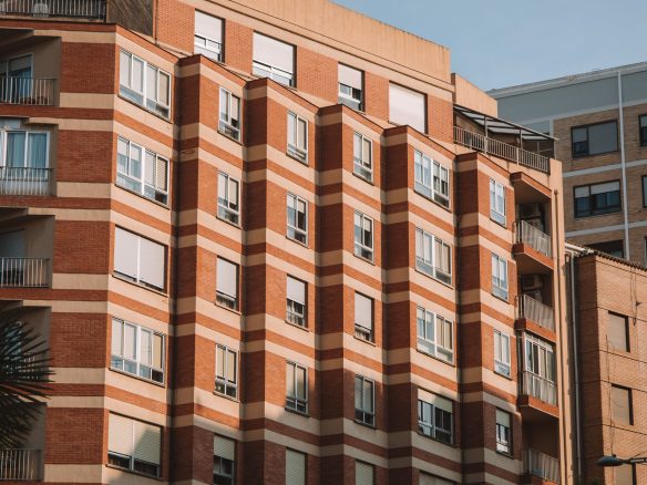 Brick apartment building in Valencia, Spain, illuminated by sunlight.