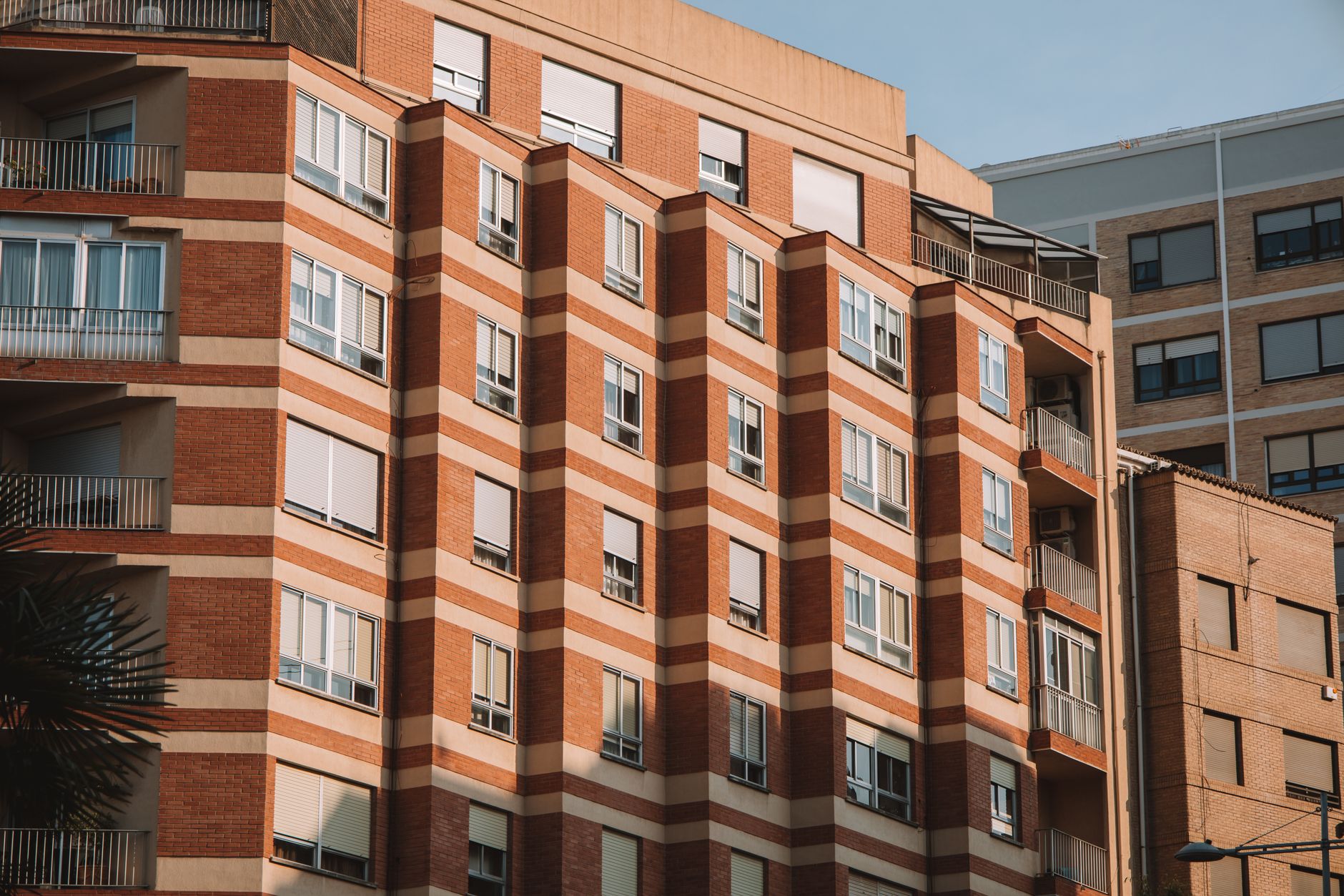 Brick apartment building in Valencia, Spain, illuminated by sunlight.