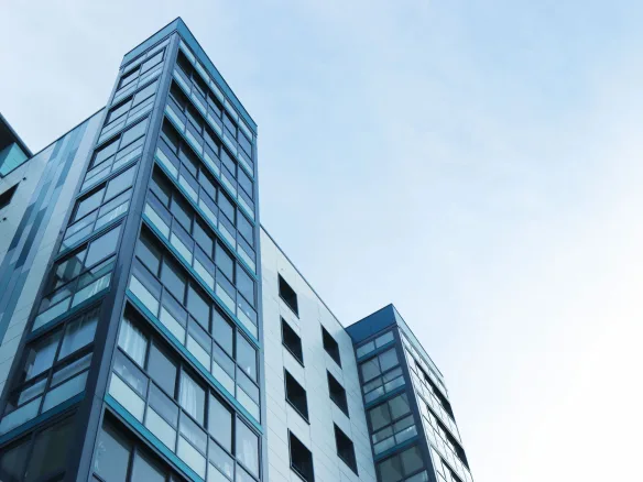 Low-angle view of a modern glass skyscraper against a clear sky in Poole, UK.